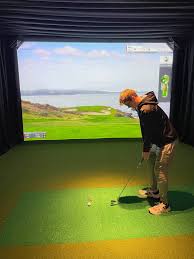 Professional indoor golf simulator at Crosswoods in Crosslake, MN, featuring high-definition screen technology, a premium hitting mat, and comfortable seating for year-round golf practice.